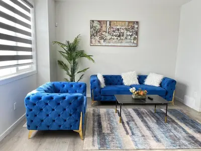 a living room with two blue couches and a table at Home in west Edmonton in Edmonton