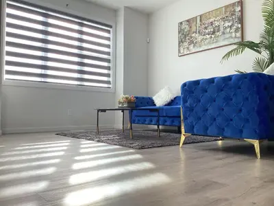 a blue couch in a living room with a table at Home in west Edmonton in Edmonton