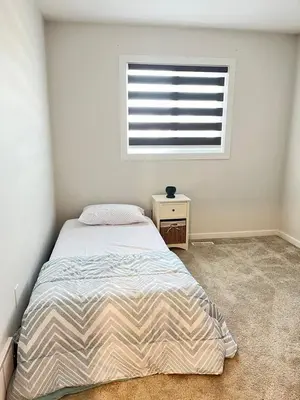 a bedroom with a large bed and a window at single house in Edmonton