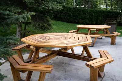 two picnic tables and a bench in a yard at Rocky Mountain Gem - One Level 750 sq ft - Hot Tub - Quiet Condo - Self Check-In - Free Parking - BBQ Fire Pit Area in Canmore
