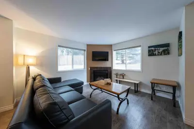 a living room with a couch and a table at Rocky Mountain Gem - One Level 750 sq ft - Hot Tub - Quiet Condo - Self Check-In - Free Parking - BBQ Fire Pit Area in Canmore