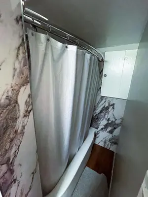 a bathroom with a toilet with a shower curtain at Shiraz Suite in Calgary