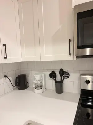 a kitchen counter with white cabinets and utensils at The Seton Nook - 1BR Suite Near Seton Health Campus, Cineplex and YMCA in Calgary