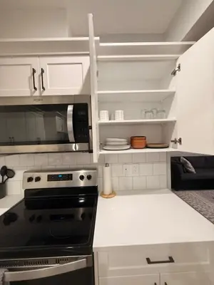 a kitchen with a stove and a microwave at The Seton Nook - 1BR Suite Near Seton Health Campus, Cineplex and YMCA in Calgary