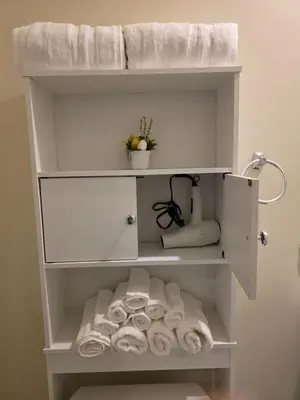 a white towel rack with towels in a bathroom at Haven YYC Guest Suite in Northwest Calgary in Calgary