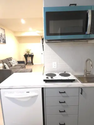 a kitchen with a sink and a stove top oven at Haven YYC Guest Suite in Northwest Calgary in Calgary