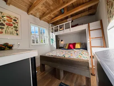 a bedroom with a bunk bed in a tiny house at Garden Cottage and Bunkie at Horner Park in Victoria