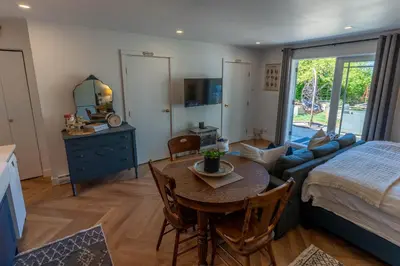 a bedroom with a bed and a table and a couch at Garden Cottage and Bunkie at Horner Park in Victoria