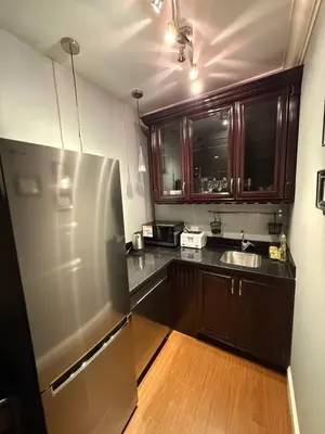 a kitchen with a stainless steel refrigerator and wooden cabinets at Peaceful & Cozy Home with 3 rooms, SHARED Bathrooms and SHARED Common Space in Vancouver