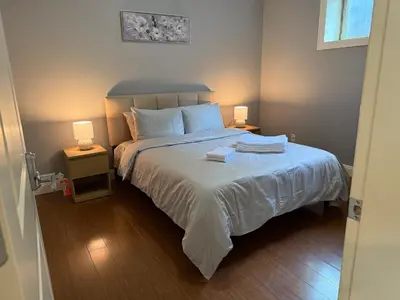 a bedroom with a large bed with two night stands at Peaceful & Cozy Home with 3 rooms, SHARED Bathrooms and SHARED Common Space in Vancouver