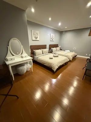 a bedroom with two beds and a vanity and a mirror at Peaceful & Cozy Home with 3 rooms, SHARED Bathrooms and SHARED Common Space in Vancouver