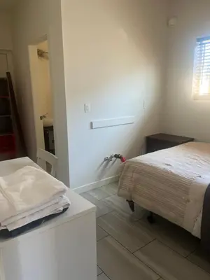a white room with a bed and a bathroom at three bedroom near uvic in Victoria