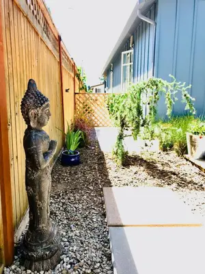 a statue of a woman with a hat in a garden at Getaway Carriage House - Great Location! Private! in Penticton