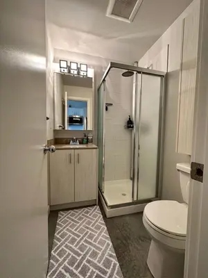 a bathroom with a shower and a toilet and a sink at Getaway Carriage House - Great Location! Private! in Penticton