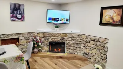 a living room with a stone fireplace and a tv at 4th Street Studio By Downtown and Airport in Calgary