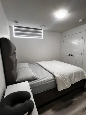 a bedroom with a bed and a chair at Cozy Corner - 1 bedroom suite - 15 mins from airport in Calgary
