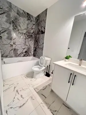 a white bathroom with a toilet and a sink at Cozy Corner - 1 bedroom suite - 15 mins from airport in Calgary