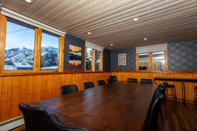 a conference room with a large wooden table and chairs at Mountain View Retreat in the heart of Banff - Massive House Sleeps 23 in Banff