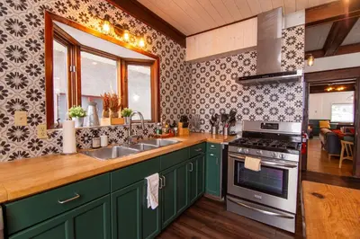 a kitchen with green cabinets and a sink and a stove at Mountain View Retreat in the heart of Banff - Massive House Sleeps 23 in Banff