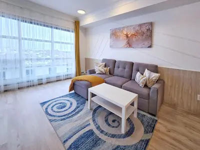 a living room with a couch and a table at Family Modern 1BR and Den Condo - Apartment with City View, Downtown, Balcony, Free Parking & In-Suite Laundry! in Calgary