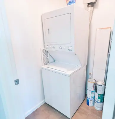 a washer and dryer in a room with a refrigerator at City View 2 King Suites Floor-to-Ceiling Views in Calgary