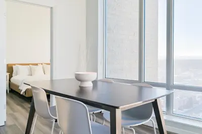 a dining room with a table and chairs and a bed at City View 2 King Suites Floor-to-Ceiling Views in Calgary