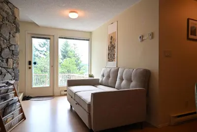a living room with a couch and a stone fireplace at Departure view in Nanaimo