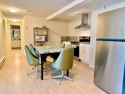 a kitchen with a dining room table and green chairs at Departure view in Nanaimo