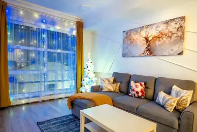 a living room with a couch and a christmas tree at Family Stylish 1BR and Den Condo -Apartment with City View, Downtown, Balcony, Free Parking, In-Suite Laundry! in Calgary