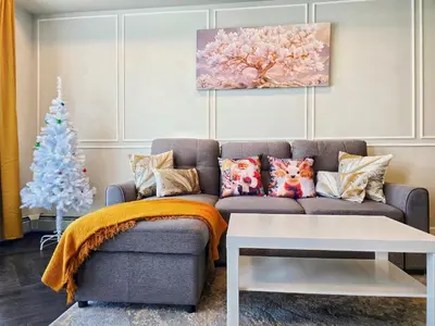 a living room with a couch and a christmas tree at Family Stylish 1BR and Den Condo -Apartment with City View, Downtown, Balcony, Free Parking, In-Suite Laundry! in Calgary