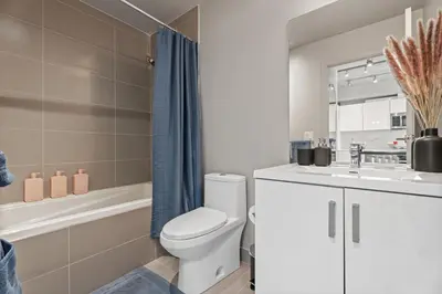 a bathroom with a toilet and a sink and a tub at Vibrant PopArt downtown suite, comfy and stylish! in Calgary