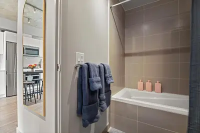 a bathroom with a bath tub and a sink at Vibrant PopArt downtown suite, comfy and stylish! in Calgary