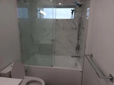 a bathroom with a shower and a toilet with a glass door at Urban Elegance: Spacious 2-Bed Townhouse with Modern Charm in Vancouver