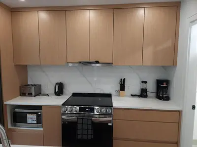 a kitchen with a stove and wooden cabinets at Urban Elegance: Spacious 2-Bed Townhouse with Modern Charm in Vancouver