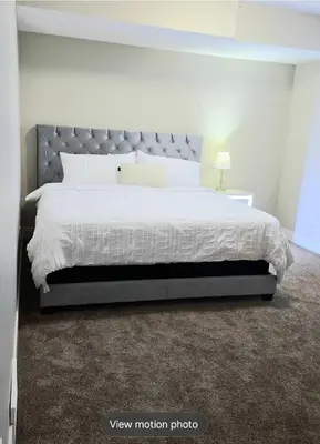 a bedroom with a large bed with a gray headboard at Golden Acreage Getaway 2 Bedroom in Balzac