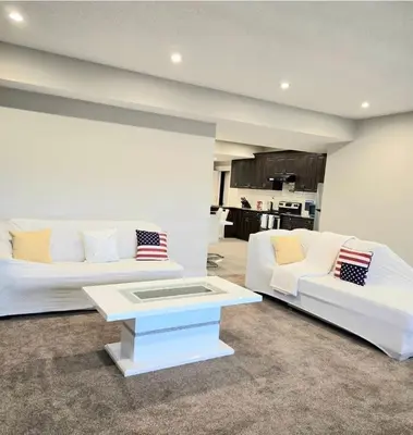 a living room with a white couch and a table at Golden Acreage Getaway 2 Bedroom in Balzac