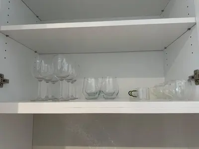 a row of wine glasses sitting on a shelf at Scenic 2BR RiverView Suite in Downtown in Calgary
