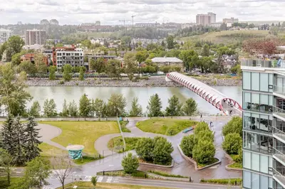 a roller coaster in a park next to a building at Scenic 2BR RiverView Suite in Downtown in Calgary