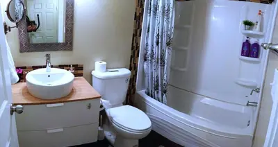a bathroom with a toilet and a sink and a shower at Private & Beautifully Finished Suite, Windermere in Edmonton