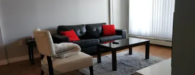 a living room with a couch and a table and a chair at Elevated Living: 2-Bedroom Upper Apartment in Calgary