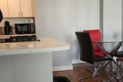 a kitchen with a table and two chairs and a microwave at Elevated Living: 2-Bedroom Upper Apartment in Calgary
