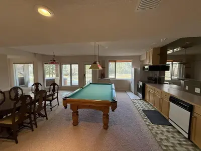 a kitchen with a pool table in the middle of a room at Spacious mountain view guesthouse in Calgary
