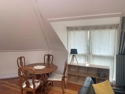 a living room with a table and a couch at Cozy and rustic cabin in Nelson