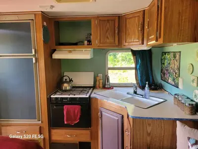 a small kitchen with a stove and a sink at Rara's secret nest in Aiyansh