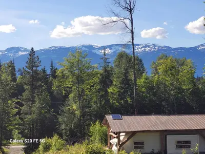 a cabin in the woods with mountains in the background at Rara's secret nest in Aiyansh