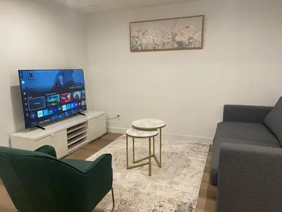 a living room with a tv and a couch and a table at Westminister Manor in Calgary