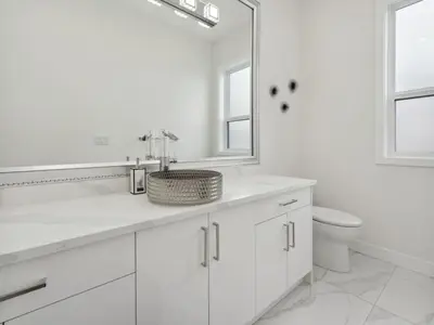 a white bathroom with a sink and a toilet at Spacious 4BR Langley Home in Langley