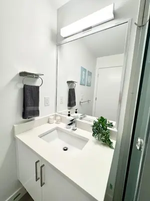 a white bathroom with a sink and a mirror at Perfect Vancouver Travel Hub for Couples or Family in Vancouver