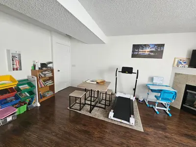 a room with chairs and a table and a fireplace at Basement Appartment in Edmonton