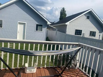 a hammock on a fence next to a house at Basement Appartment in Edmonton